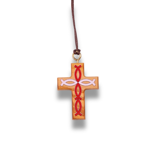 Olive wood cross pendant with red fish symbols on a brown cord against a white background