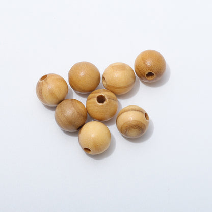 Close-up of loose 8mm round olive wood beads showing natural grain and drilled holes