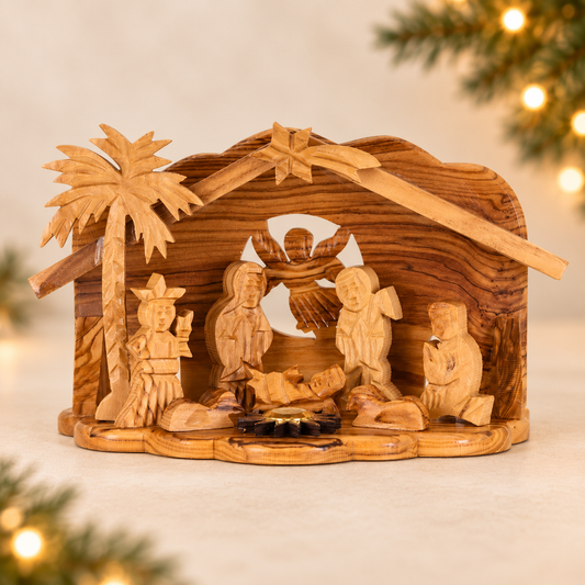 Hand-carved olive wood nativity scene with a stable, palm tree, and multiple figures