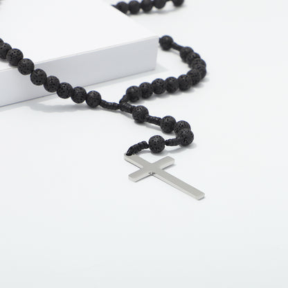 Close view of the plain metal cross and lava beads on knotted cord