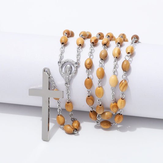 Oval olive wood rosary with Virgin Mary centerpiece draped over a white block