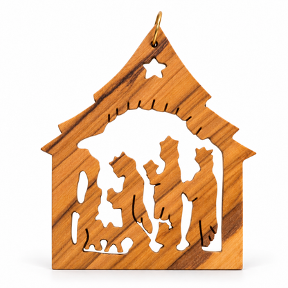 A small wooden nativity ornament with a warm honey-wood grain pattern, featuring cutouts of the Holy Family and a star at the top, hanging from a gold-colored loop on a white background.