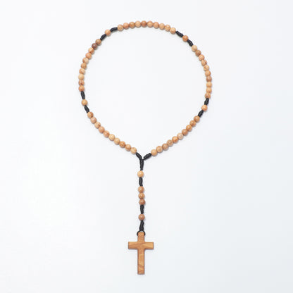Full view of the olive wood pocket rosary with small round beads, black knotted cord and a plain wooden cross