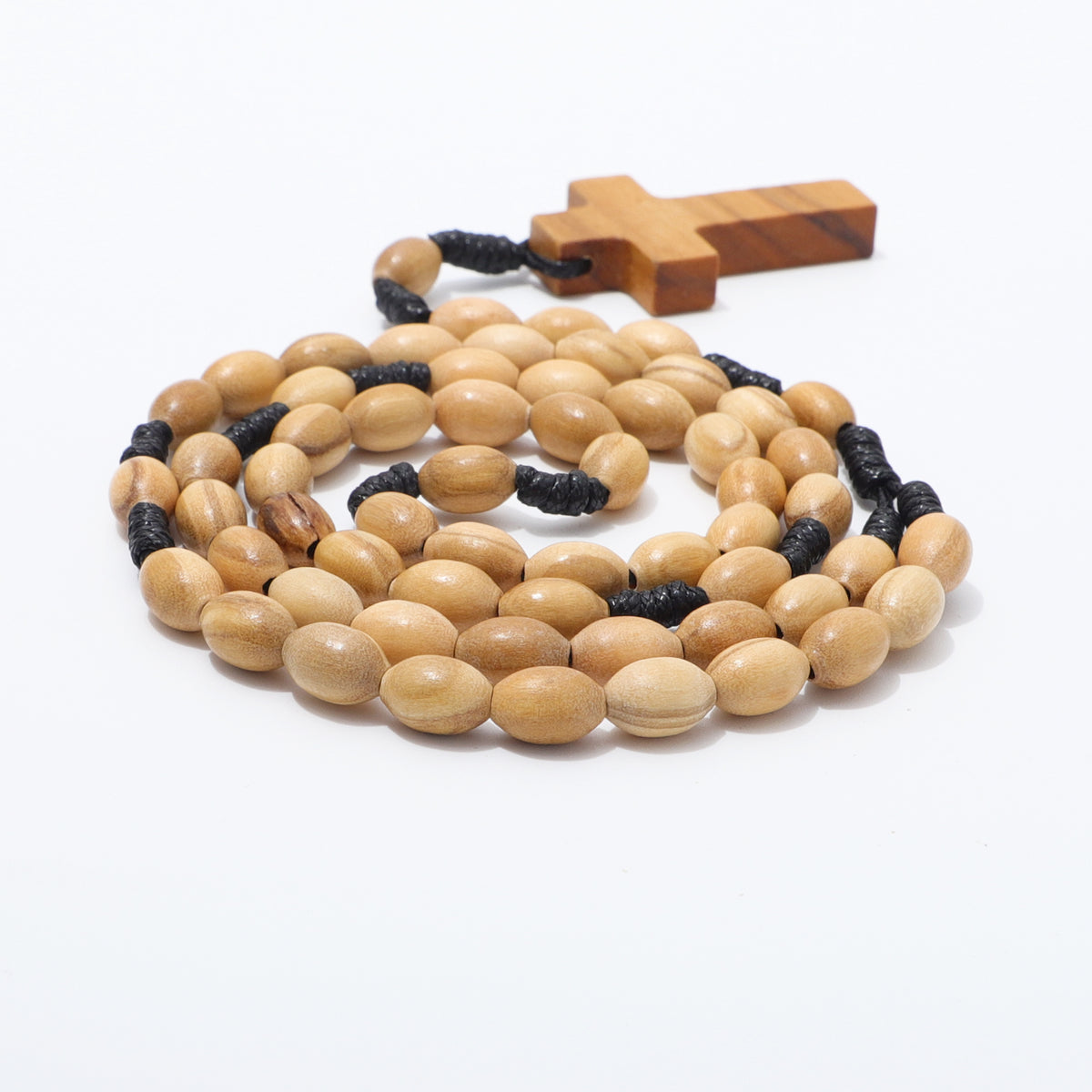Side view of coiled oval olive wood beads on black knotted cord with a wooden cross