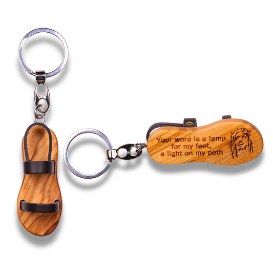 Wooden sandal-shaped keychain with engraved text on a white background