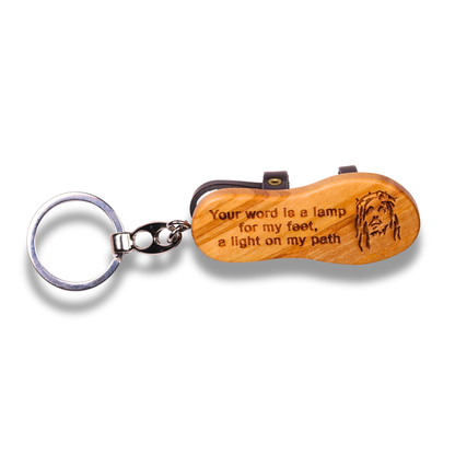 Wooden keychain with engraved text and a face design on a white background