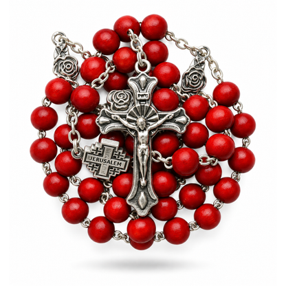 Red bead rosary coiled around a Jerusalem Cross centerpiece and silver toned crucifix