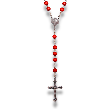 Red rosary beads and silver toned crucifix shown hanging vertically