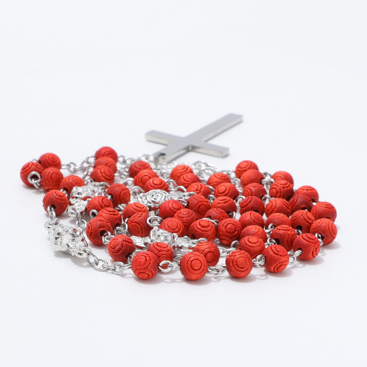 Close view of engraved circular patterns on red rosary beads