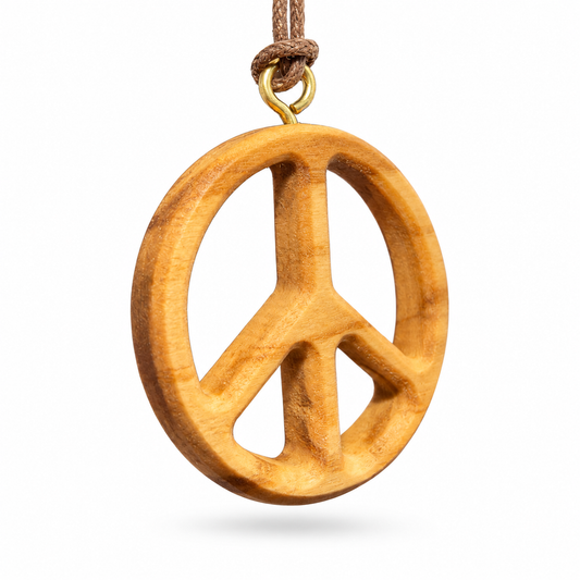 A wooden peace sign pendant with a natural light brown finish, suspended from a brown cord with a gold-colored metal ring, shown against a plain white background.