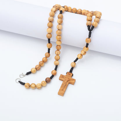 Olive wood five-decade rosary necklace with clasp and crucifix draped over a white block