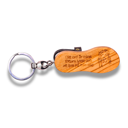 Wooden keychain with engraved text and a dog illustration on a white background