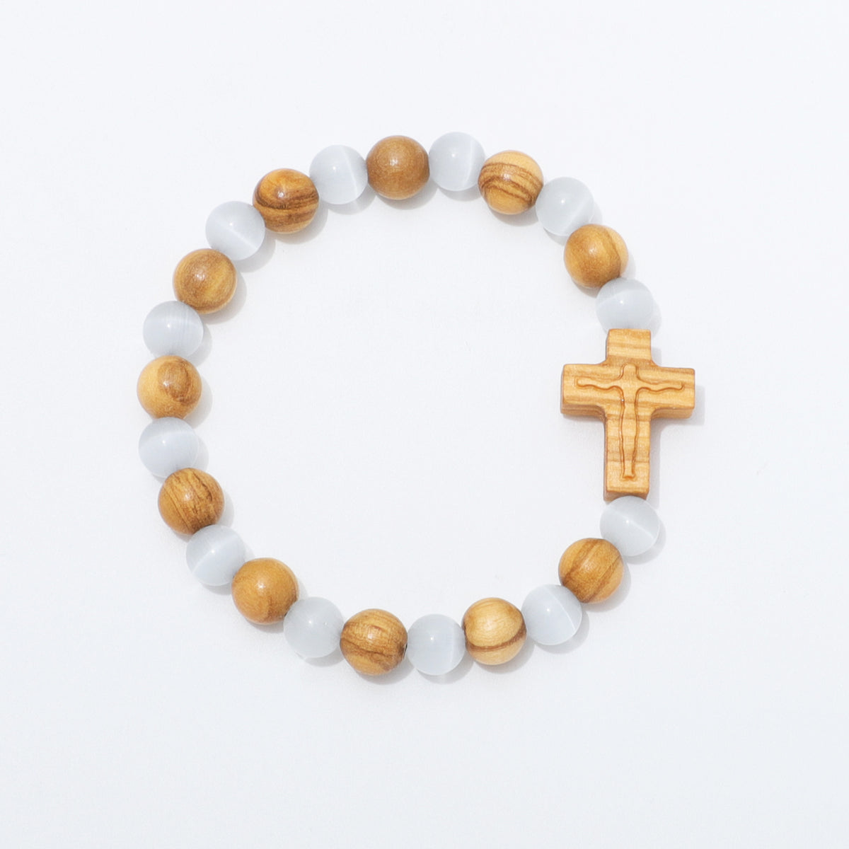 A beaded stretch bracelet featuring light brown wooden beads, translucent white cat's eye beads, and a carved wooden crucifix, displayed on a clean white background.