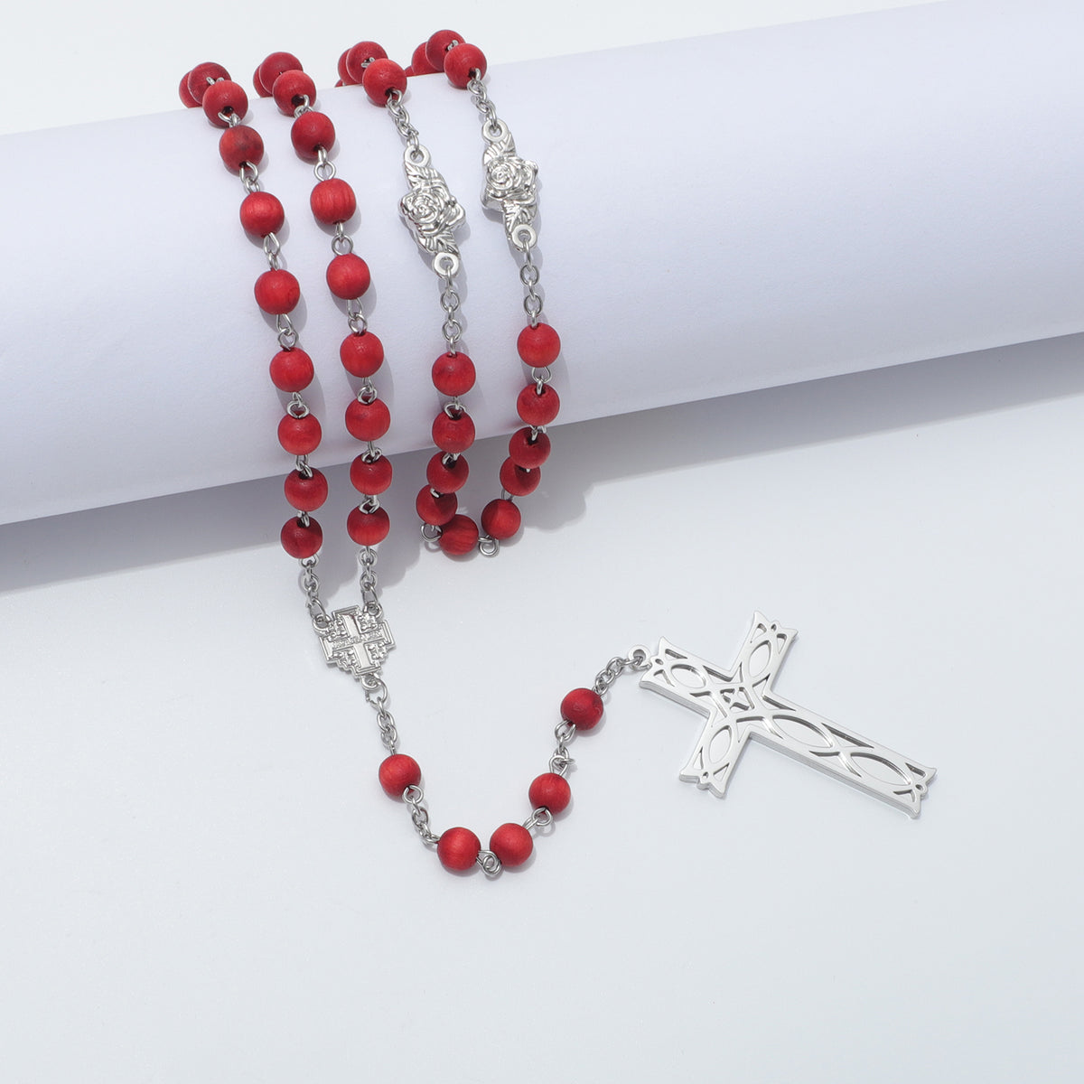 Red beads and Ichthus Cross draped over a white block with Jerusalem Cross centerpiece