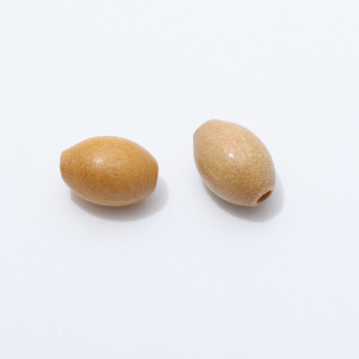 Close up of two 6 × 9mm oval olive wood beads on a white background