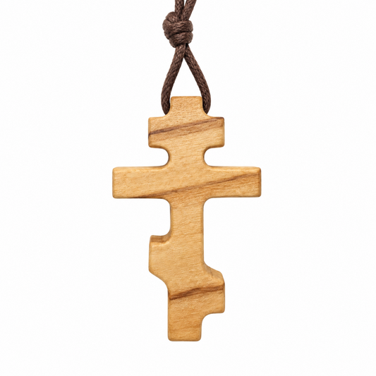 Small Russian Orthodox olive wood cross necklace with natural wood grain and brown cotton cord, front view.