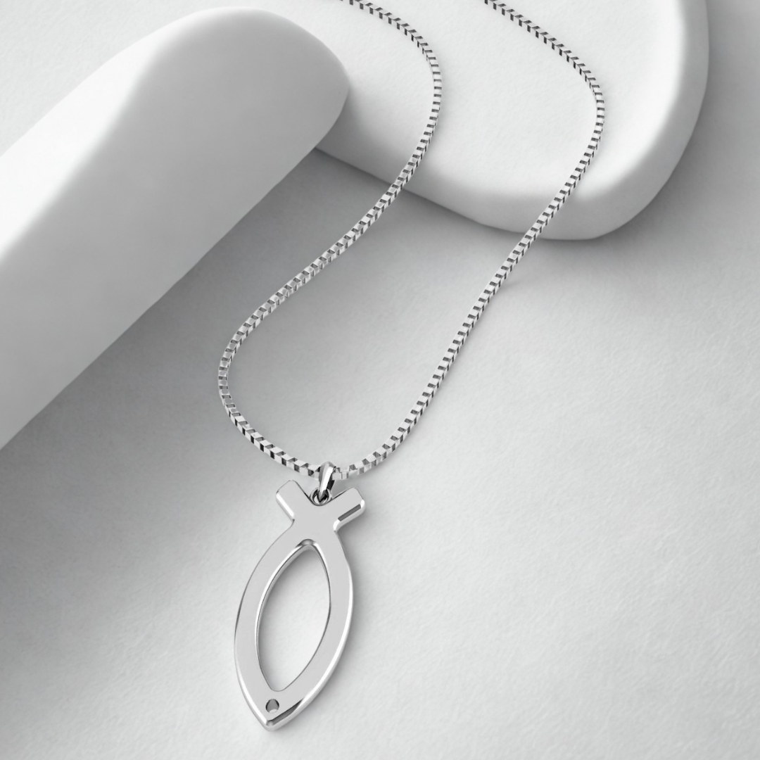 Silver fish-shaped pendant on a chain against a light gray background